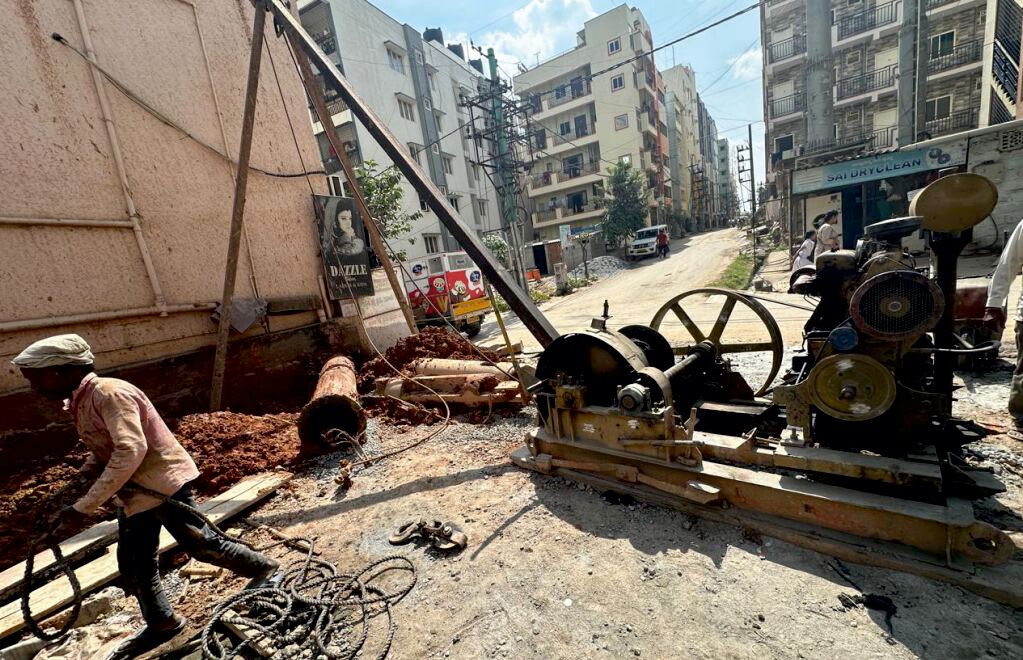Traditional cable percussion rig drilling in a narrow urban lane in Bengaluru